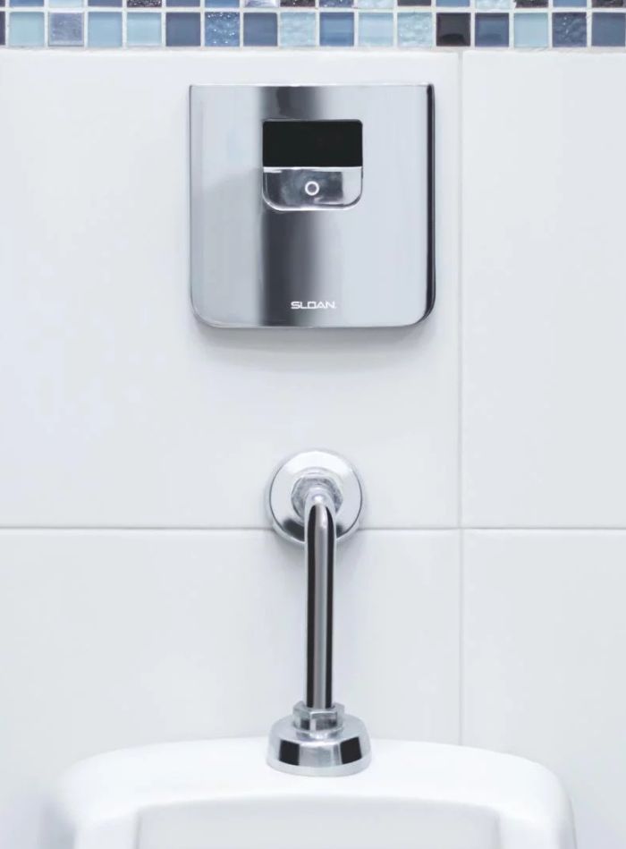 Chrome Sloan automatic flushometer with sensor technology, ensuring water savings and touch-free hygiene for urinals.
