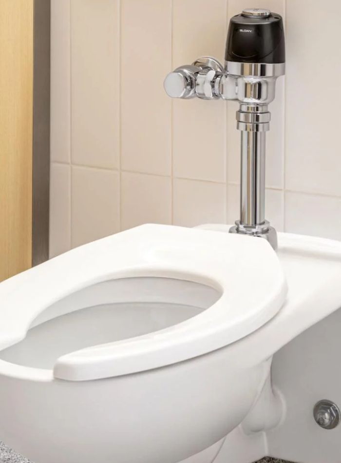 Toilet equipped with a Sloan automatic sensor flushometer, providing a modern, clean, and sustainable experience.