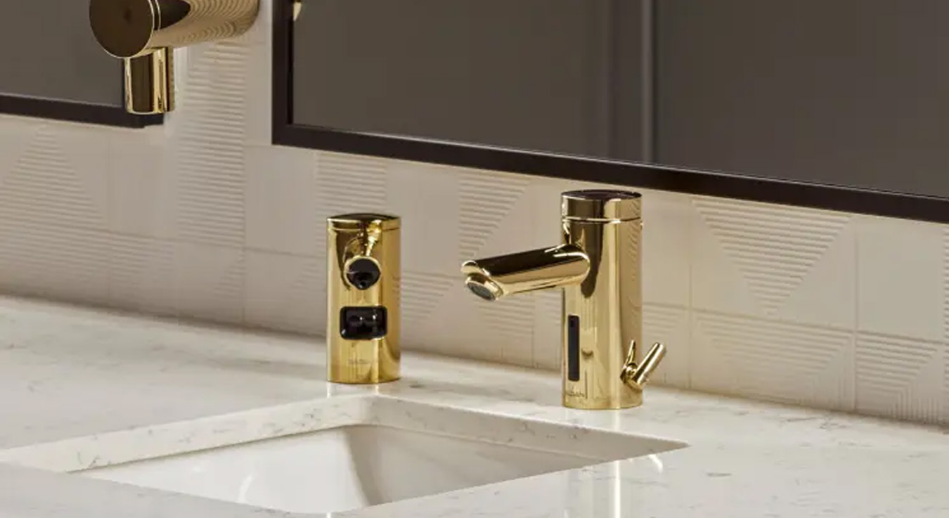 a lavatory station with Sloan automatic faucet and soap dispenser in a gold finish, adding a touch of modern luxury and sophistication to the space. The cylindrical, minimalist design integrates sensor-activated technology, ensuring a touch-free, hygienic, and efficient experience.