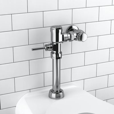 Sloan manual flushometer in polished chrome finish installed above a toilet against a white subway tile wall.