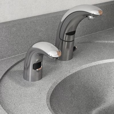 Sloan automatic faucet and soap dispenser in chrome finish, installed on a gray solid-surface sink.