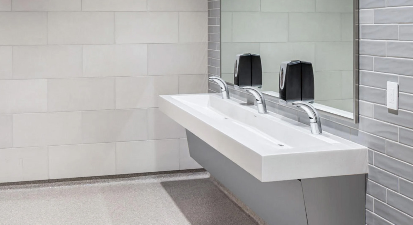 multi-user sink with Sloan sensor-activated faucets, installed at Keith Bell Opportunity Central (The OC). The setup combines modern design with touch-free hygiene and water efficiency.