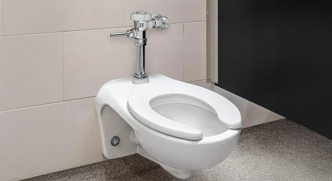 wall-mounted Sloan toilet with a manual flush valve, installed at Keith Bell Opportunity Central (The OC). This setup offers durability, water efficiency, and accessibility — ideal for educational or high-traffic facilities.