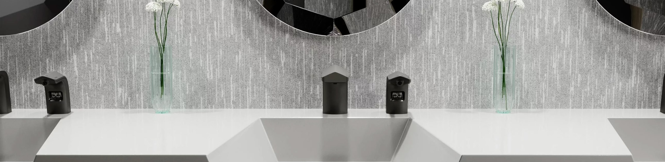 a contemporary Sloan® sink with a geometric design and neutral finishes. Each station includes black automatic faucets and soap dispensers, creating a sleek and modern look