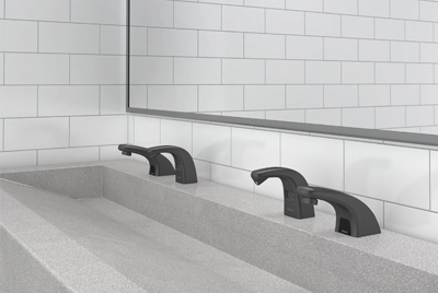 a solid-surface sink with Sloan® matte black automatic faucets, elegantly contrasting with the white tiled background