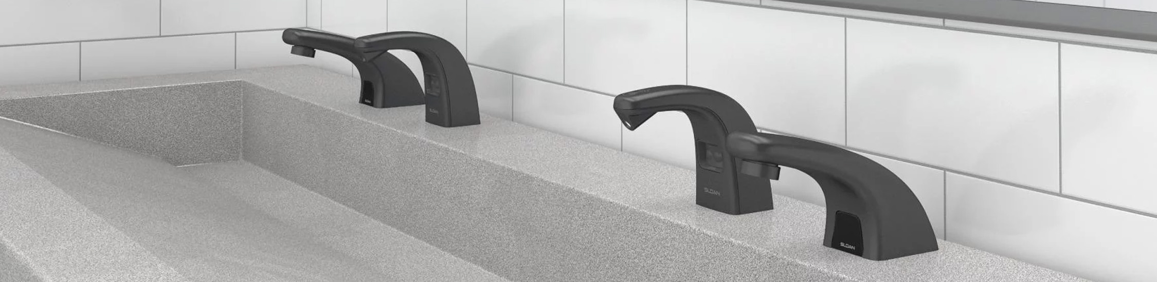 a solid-surface sink with Sloan® matte black automatic faucets, elegantly contrasting with the white tiled background