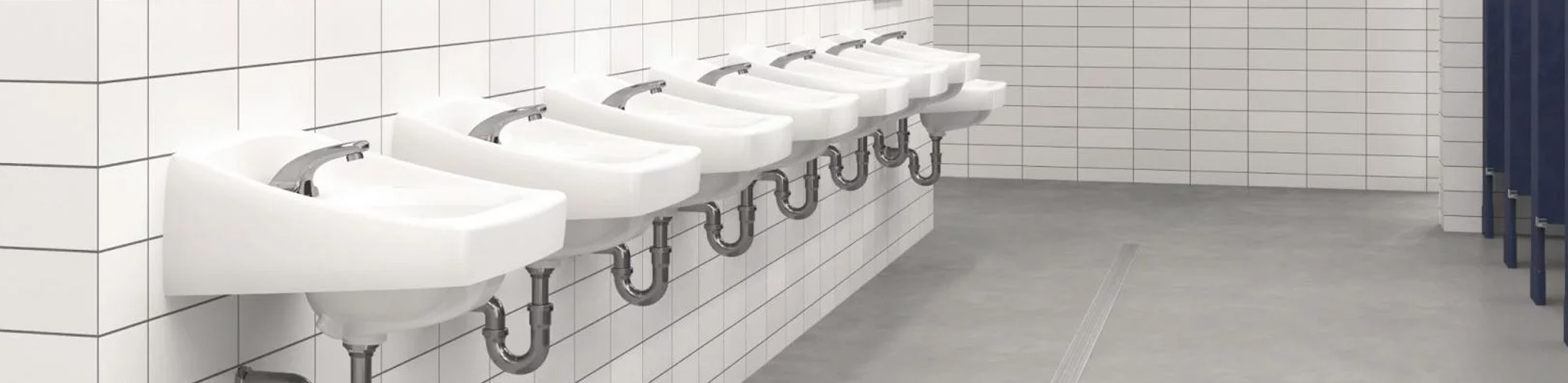 a large-capacity institutional restroom, featuring a row of wall-mounted sinks aligned with wide mirrors.