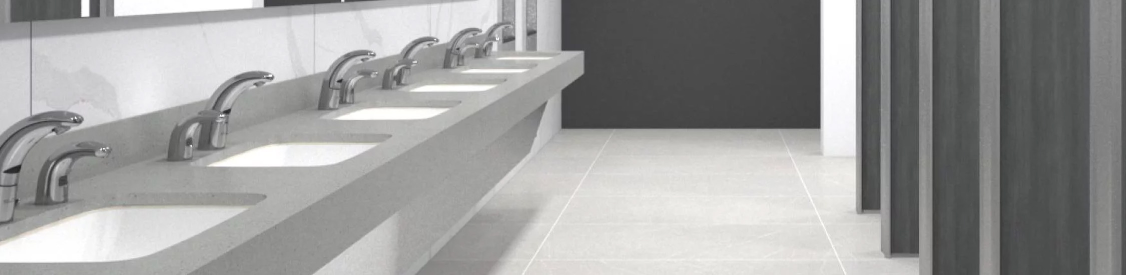 a contemporary corporate-style restroom, featuring a long integrated sink counter with Sloan® automatic chrome faucets.