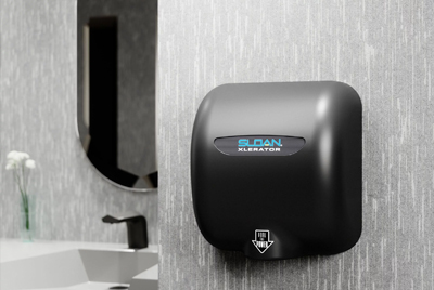 a Sloan® XLERATOR® hand dryer in a matte black finish, mounted next to a sensor-activated faucet.
