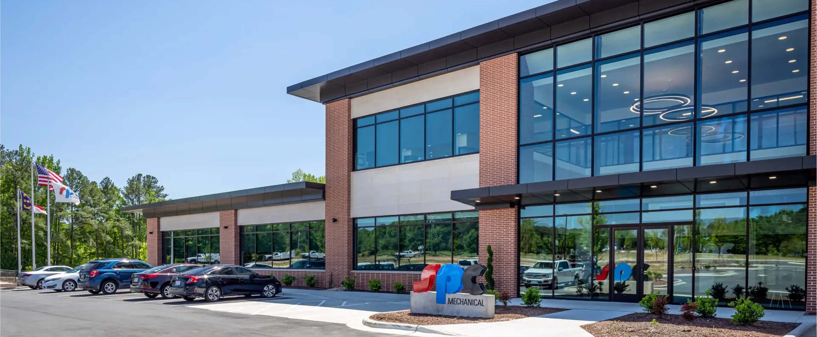 the SPC Mechanical Headquarters, a contemporary corporate building featuring clean lines, expansive windows, and modern materials such as brick, glass, and metal. Its architecture conveys a sense of innovation, transparency, and corporate strength, perfectly aligned with the company’s technical and professional identity.