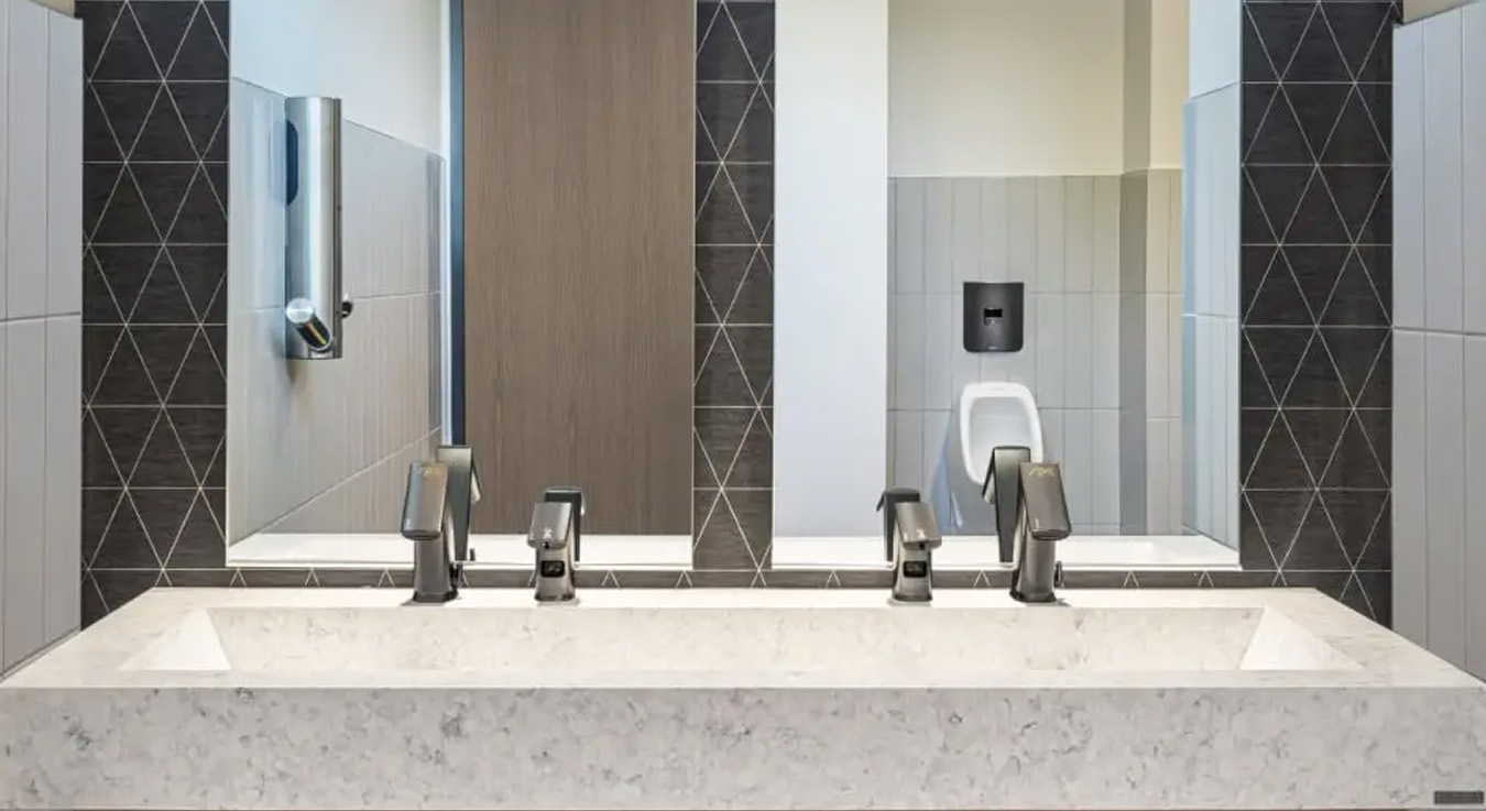 the handwashing area at SPC Mechanical Headquarters, featuring Sloan automatic sensor faucets in a graphite finish, harmonizing with the space’s modern design.