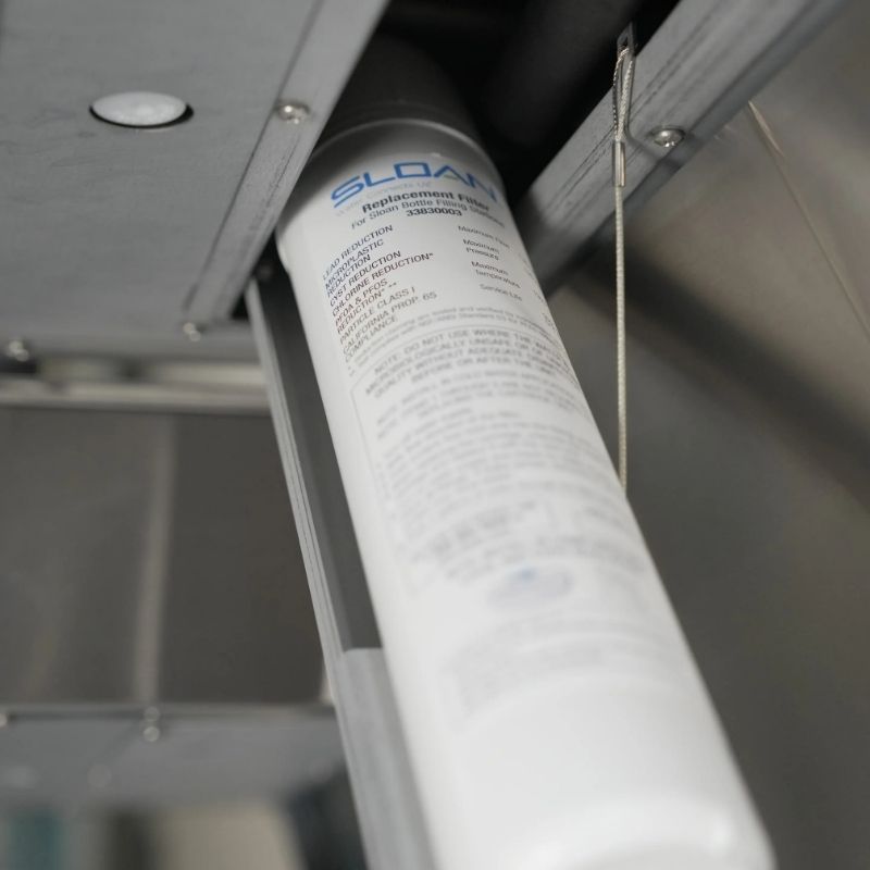 Sloan replacement filter installed inside a bottle filling system, showing the label with technical specifications.