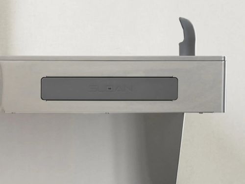 Barra frontal de empuje de acero inoxidable en un dispensador de agua para botellas, diseñada para una activación fácil y sin contacto.