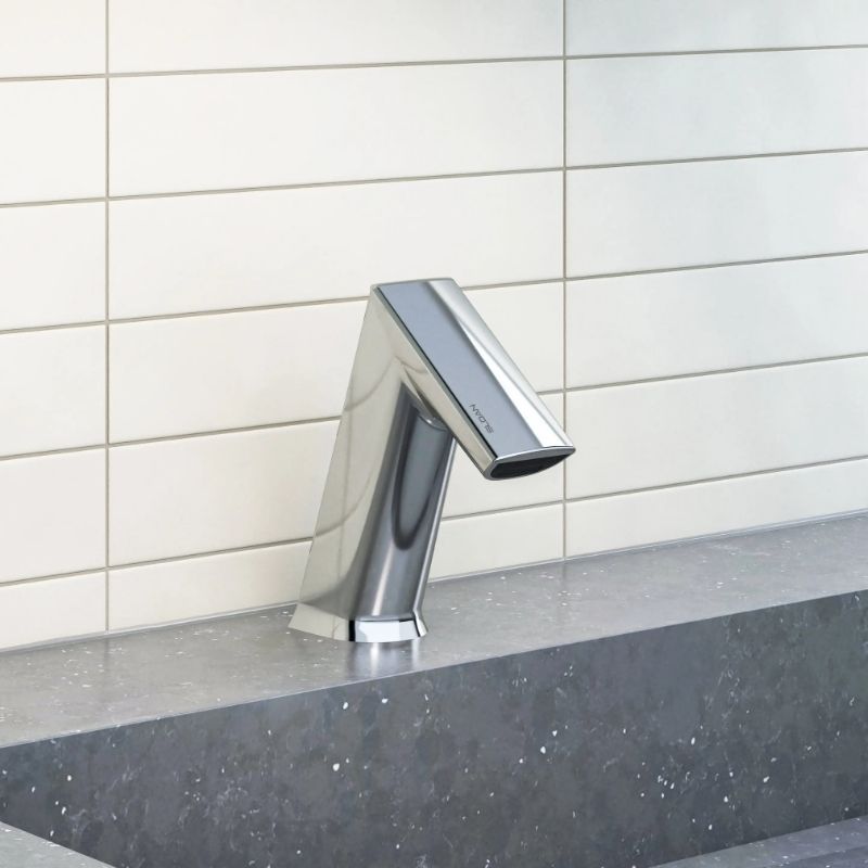 Sloan automatic chrome faucet installed on a gray stone countertop with white rectangular tile backsplash.