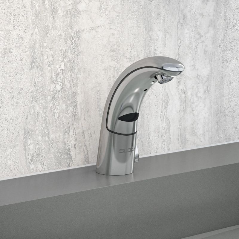 Sloan automatic chrome faucet with curved design, installed on a gray countertop with a light stone-textured backsplash.