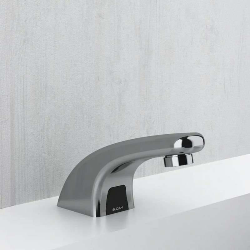 Sloan compact chrome automatic faucet with curved design, mounted on a white countertop and light gray wall background.