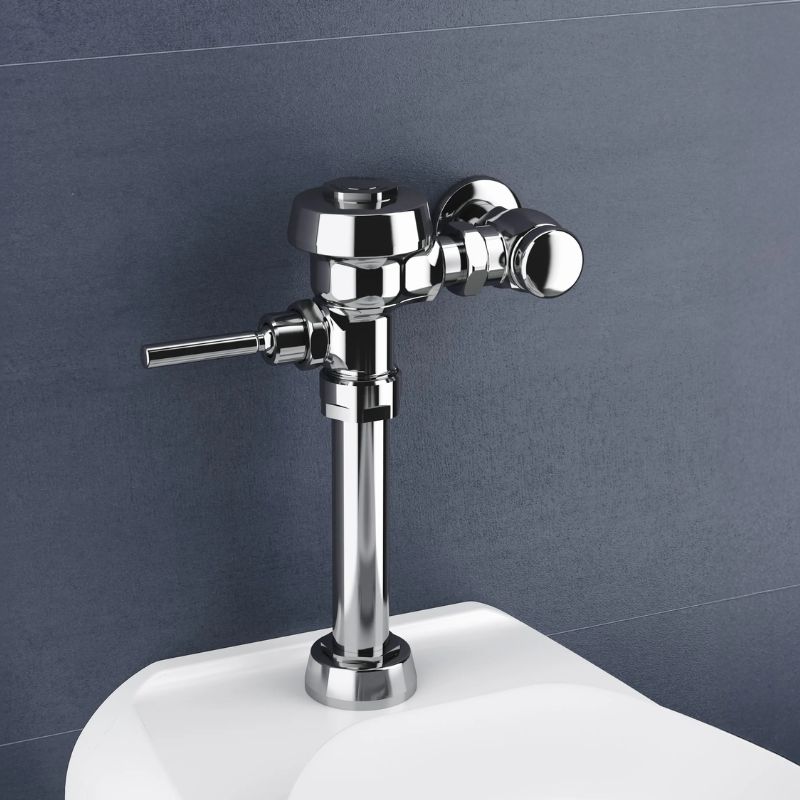 Sloan manual flushometer in polished chrome finish installed above a toilet against a dark blue wall.