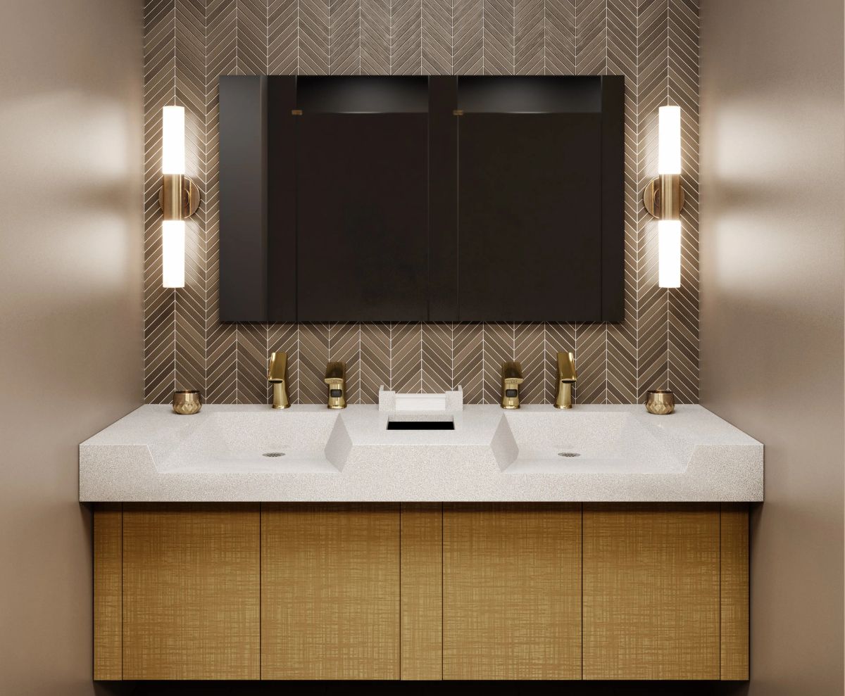 Double solid-surface sink with gold faucets, black mirror, and vertical light fixtures in a sophisticated bathroom setting.