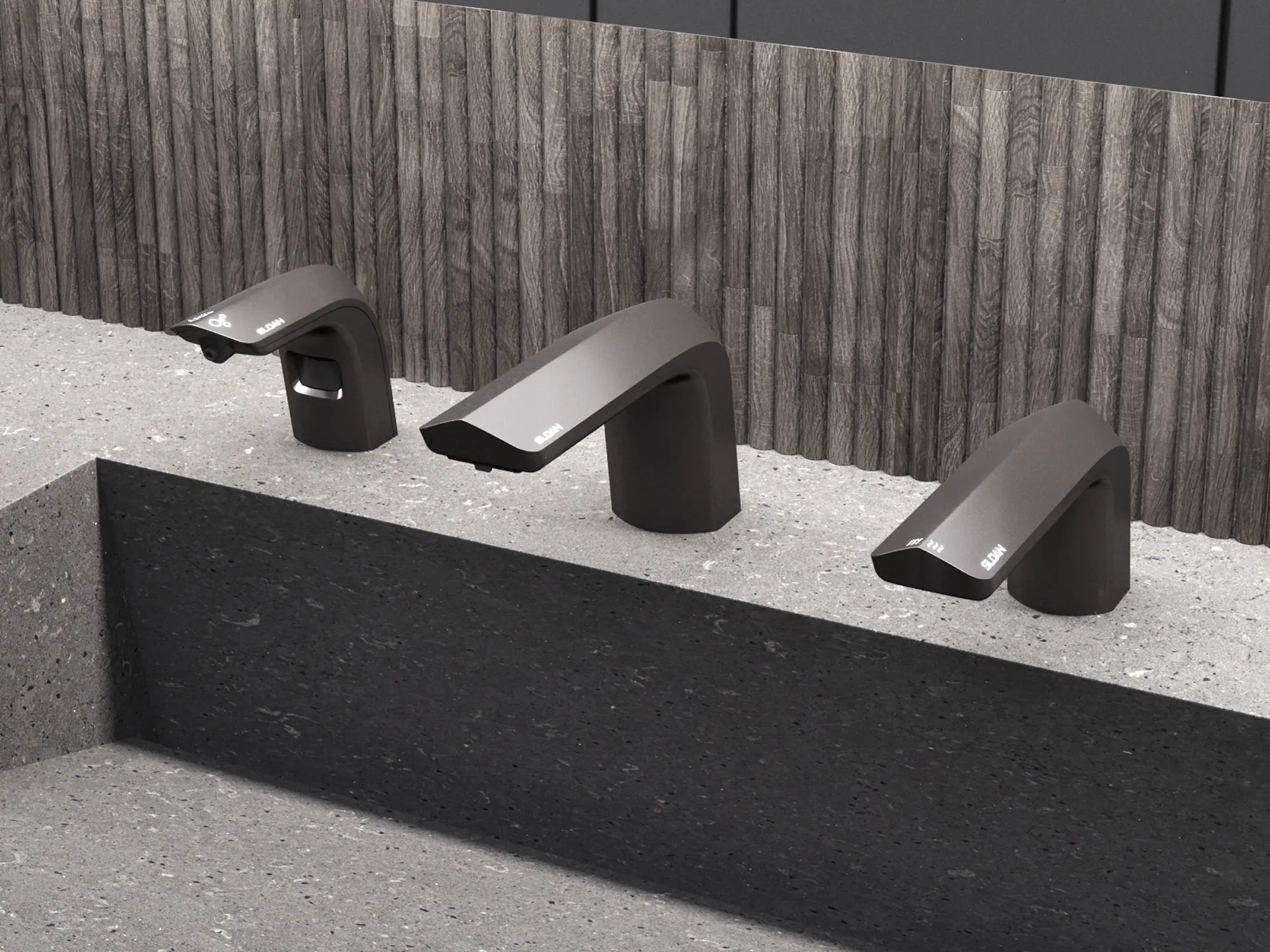 Sloan faucet and hand dryer system in graphite finish, installed on a textured stone counter with a modern wood backdrop.