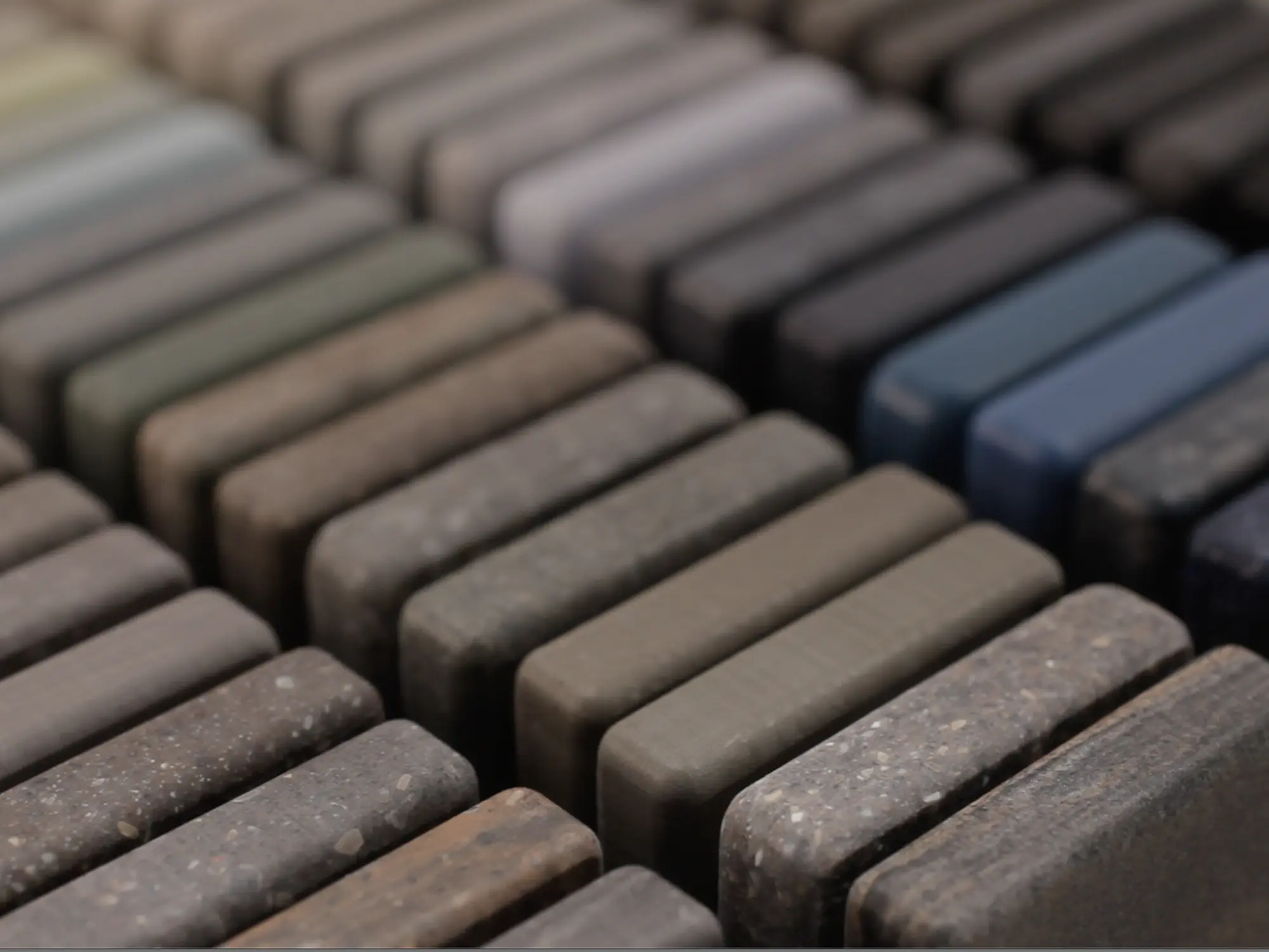 Selection of solid surface material samples in a variety of neutral and natural tones for custom sink design.