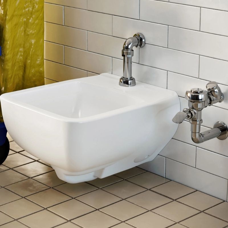 Wall-mounted commercial service sink with a Sloan foot pedal faucet, ideal for janitorial and maintenance areas.