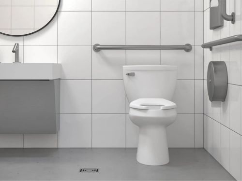 Baño accesible con lavabo mural, sanitario con barra de apoyo y dispensador de papel, diseñado para personas con movilidad reducida.