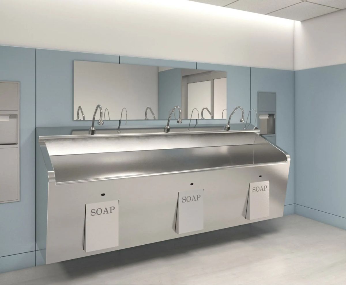 Estación de lavado de manos de acero inoxidable con múltiples grifos y dispensadores automáticos de jabón, diseñada para entornos hospitalarios o quirúrgicos.