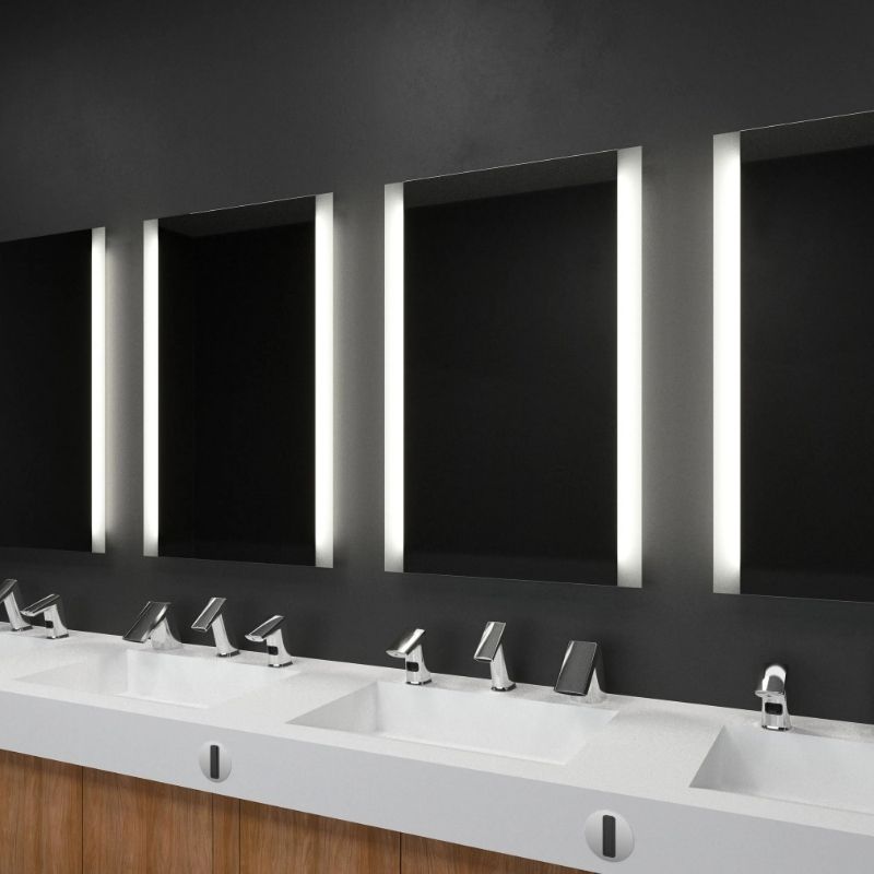 Wash stations featuring Sloan automatic faucets and backlit mirrors, blending matte black, wood, and white surface finishes.