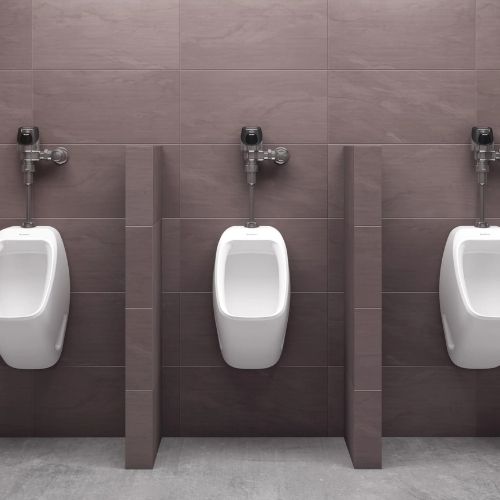 Urinals with Sloan automatic flushometers in polished chrome finish installed on a dark brown tiled wall.