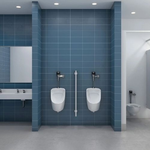 Urinals with Sloan automatic flushometers mounted on a blue tiled wall in a modern restroom with sink area and private stall.