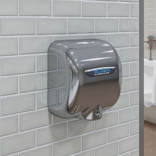 Stainless steel Sloan XLERATOR hand dryer mounted on a wall with glossy gray tiles in a public restroom.