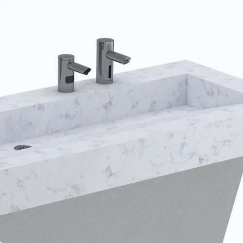 White marble sink with integrated Sloan automatic faucets for washing and soap dispensing.