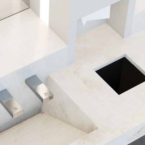Lavabo de superficie sólida color marfil con grifos automáticos Sloan e integrada zona de secado, diseñado para ofrecer una experiencia sin contacto.