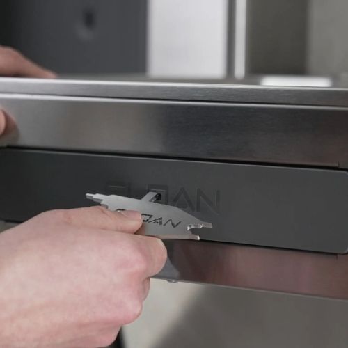 Hands using a Sloan tool to remove the front access panel of a water bottle filler.