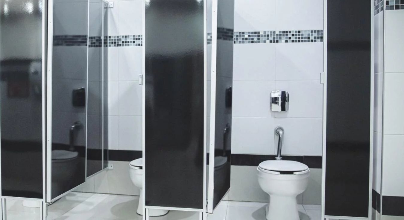 Renovated restrooms with individual stalls in black and white tones, providing cleanliness, privacy, and comfort for visitors.