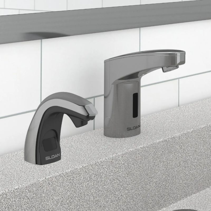 Sloan automatic faucet and soap dispenser in chrome finish with black accents, installed on a textured gray countertop with a white tile background.