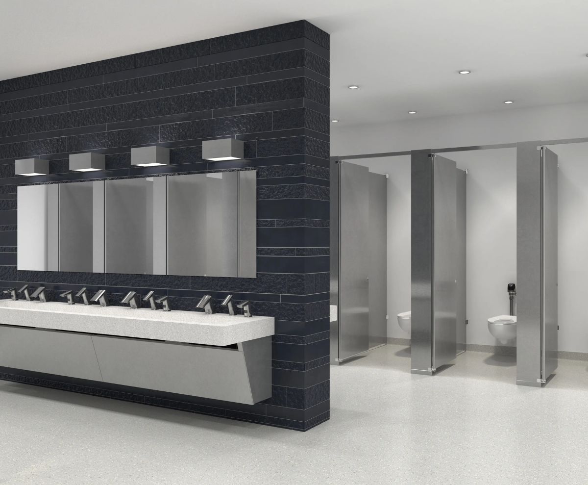 Contemporary public restroom with automatic faucets, large mirrors, and stainless steel stalls, designed for high-traffic areas such as airports or stations.