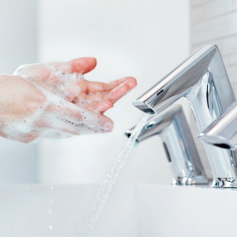 Hands washing with soap under Sloan touchless faucets