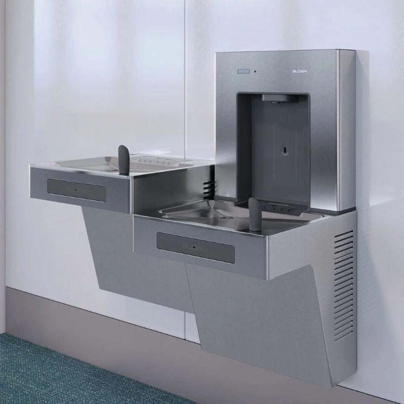Stainless steel Sloan wall-mounted bottle filler and dual drinking fountains installed in a public corridor.