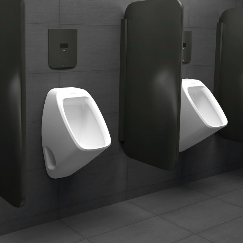 Sloan urinals with concealed automatic flushometers in matte black finish, installed in a modern restroom with dark gray tiled walls.