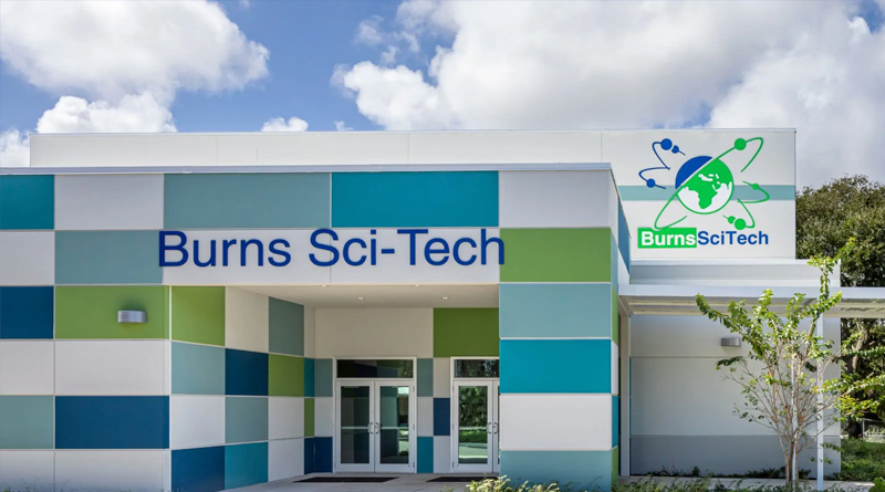 the main entrance of Burns Sci-Tech Charter School, an educational institution known for its focus on Science, Technology, Engineering, Art, and Mathematics (STEAM). The modern architecture, featuring panels in blue, green, and white, symbolizes the school’s innovative and sustainable approach to learning.